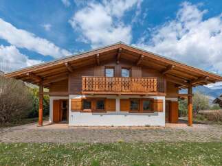 This stunning chalet-style home boasts exquisite wooden architecture and a charming balcony, perfect for enjoying the scenic views.