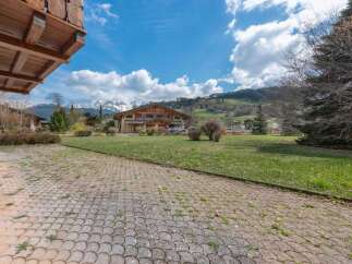Discover a stunning property nestled in a picturesque landscape, boasting a charming wooden facade and ample outdoor space.