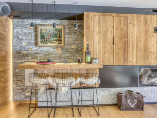 Experience rustic elegance in this stunning property, featuring a beautifully designed bar area with stylish wire chairs and a cozy fireplace.