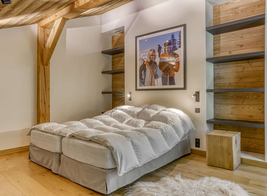 This cozy bedroom boasts a rustic charm with its wooden beams and paneling.