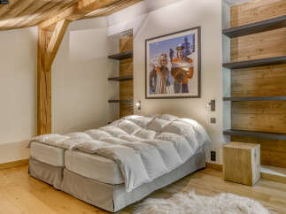 This cozy bedroom boasts a rustic charm with its wooden beams and paneling.