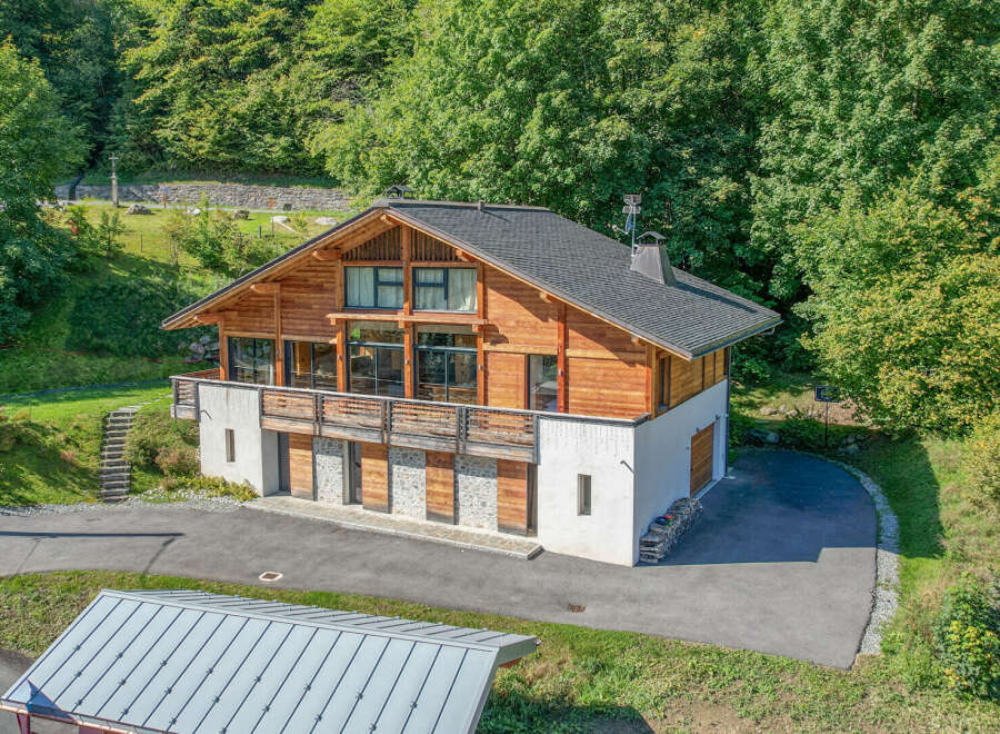 Nestled in a serene, wooded setting, this stunning chalet-style home offers a perfect blend of rustic charm and modern elegance.