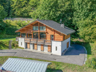 Nestled in a serene, wooded setting, this stunning chalet-style home offers a perfect blend of rustic charm and modern elegance.