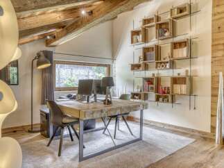 Discover the charm of this stunning home office, featuring a unique wooden desk and a custom-built bookshelf.