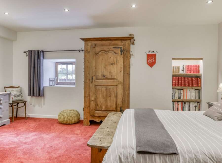 Discover the charm of this unique property, featuring a rustic wooden wardrobe and a cozy reading nook.