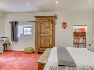 Discover the charm of this unique property, featuring a rustic wooden wardrobe and a cozy reading nook.