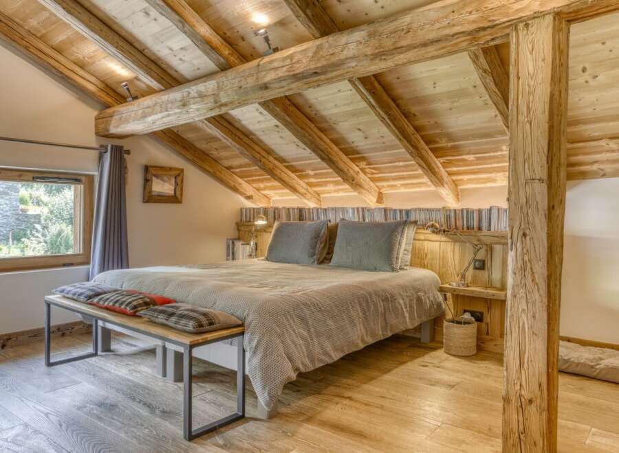 Experience rustic charm in this stunning bedroom featuring exposed wooden beams and a cozy ambiance.