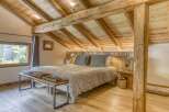 Experience rustic charm in this stunning bedroom featuring exposed wooden beams and a cozy ambiance.
