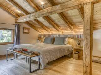 Experience rustic charm in this stunning bedroom featuring exposed wooden beams and a cozy ambiance.