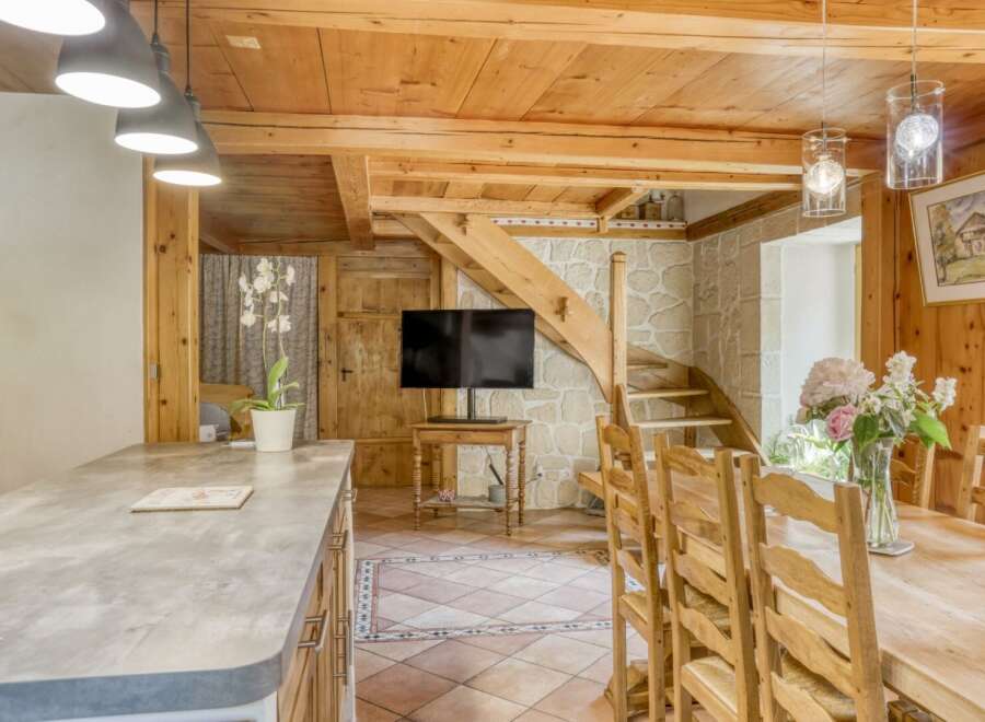 This charming property boasts a rustic interior with exposed wooden beams and a stone accent wall.