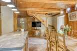 This charming property boasts a rustic interior with exposed wooden beams and a stone accent wall.