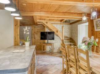 This charming property boasts a rustic interior with exposed wooden beams and a stone accent wall.
