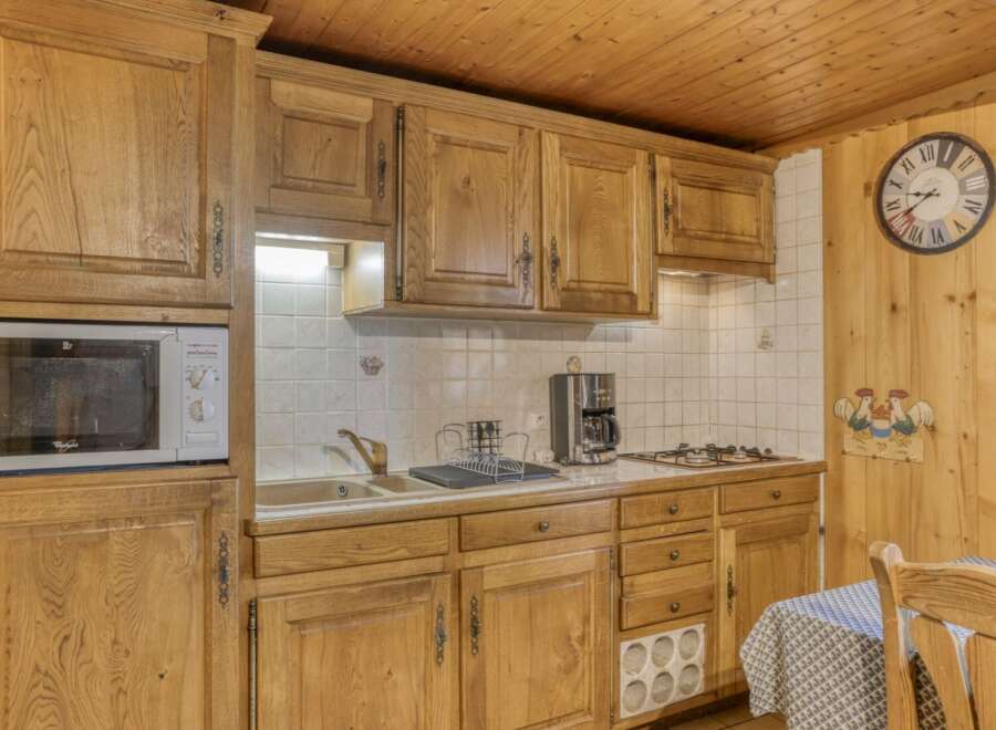 This charming kitchen features beautiful wooden cabinetry, offering ample storage and a warm, inviting atmosphere.