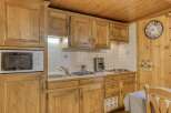 This charming kitchen features beautiful wooden cabinetry, offering ample storage and a warm, inviting atmosphere.