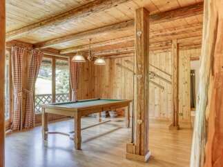 This stunning property boasts a rustic charm with its wooden interior and inviting ambiance.