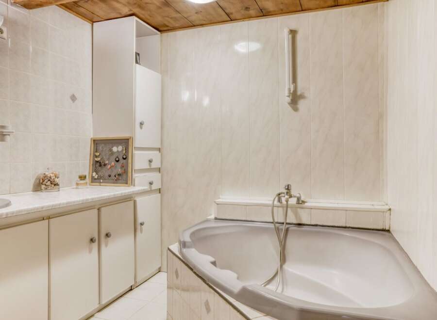 Discover the charm of this well-maintained bathroom, featuring a stylish bathtub and ample storage.