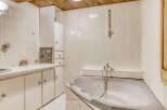 Discover the charm of this well-maintained bathroom, featuring a stylish bathtub and ample storage.