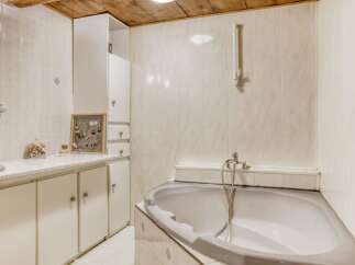 Discover the charm of this well-maintained bathroom, featuring a stylish bathtub and ample storage.