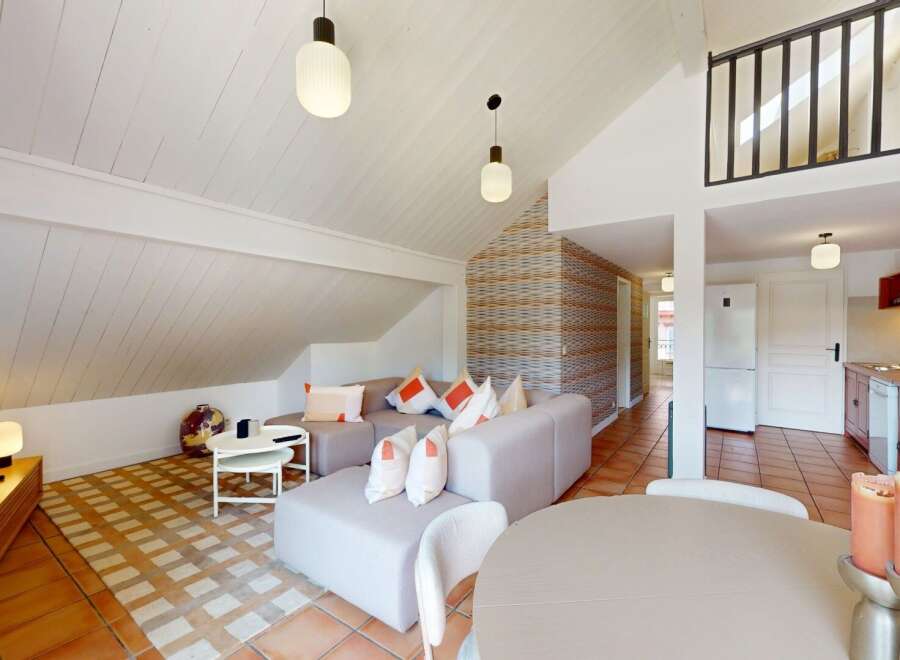 Discover this charming property featuring a stylish living area with a modern sofa and a cozy dining space.