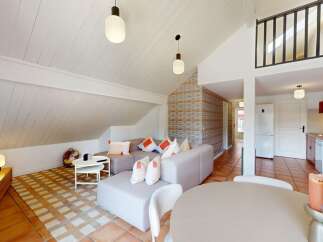 Discover this charming property featuring a stylish living area with a modern sofa and a cozy dining space.