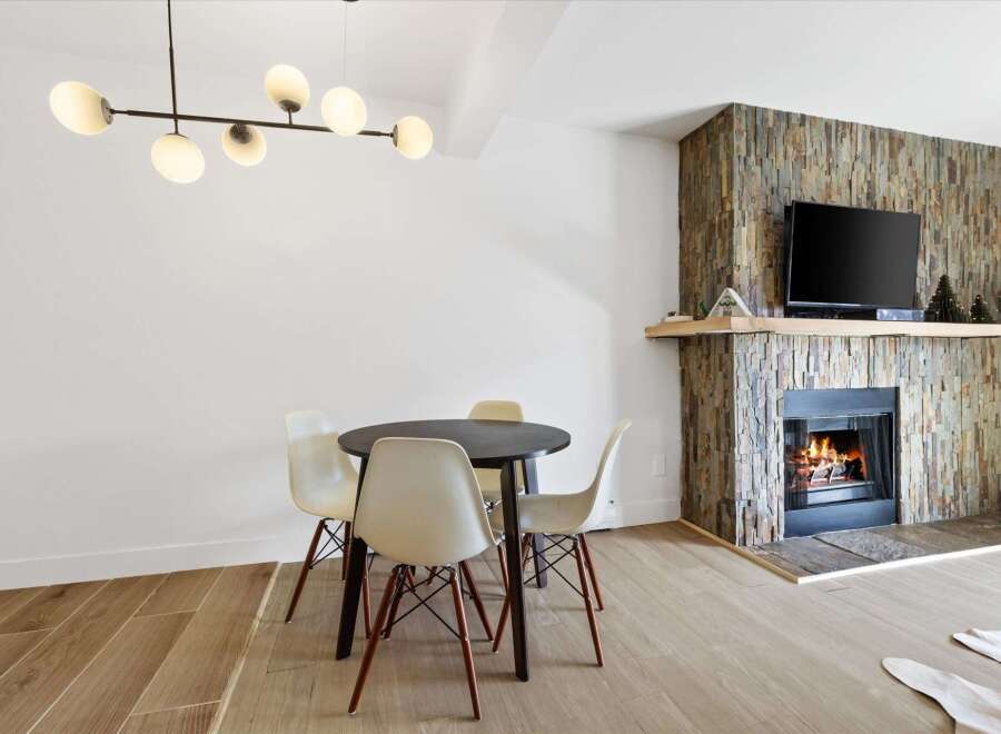 This stunning property features a cozy fireplace with a stone facade, perfect for creating a warm and inviting atmosphere.