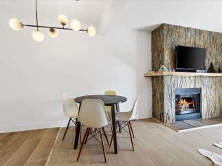 This stunning property features a cozy fireplace with a stone facade, perfect for creating a warm and inviting atmosphere.