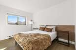 This inviting bedroom features a cozy ambiance with its plush, textured throw blanket and warm-toned accents.