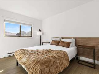 This inviting bedroom features a cozy ambiance with its plush, textured throw blanket and warm-toned accents.