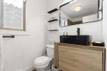 This modern bathroom features a sleek black sink and faucet, complemented by a stylish wooden vanity.