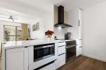 This stunning kitchen features modern appliances and sleek white cabinetry, perfect for culinary enthusiasts.