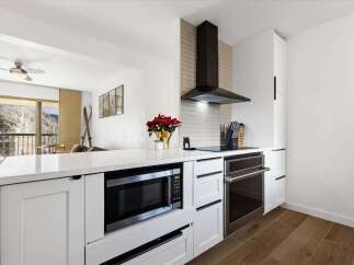 This stunning kitchen features modern appliances and sleek white cabinetry, perfect for culinary enthusiasts.