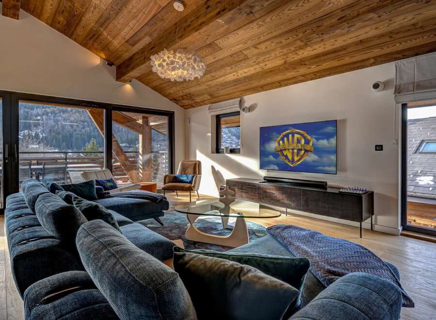 Experience luxury living in this stunning property, featuring a spacious living room with a cozy sofa and a modern entertainment setup.