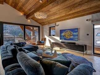 Experience luxury living in this stunning property, featuring a spacious living room with a cozy sofa and a modern entertainment setup.