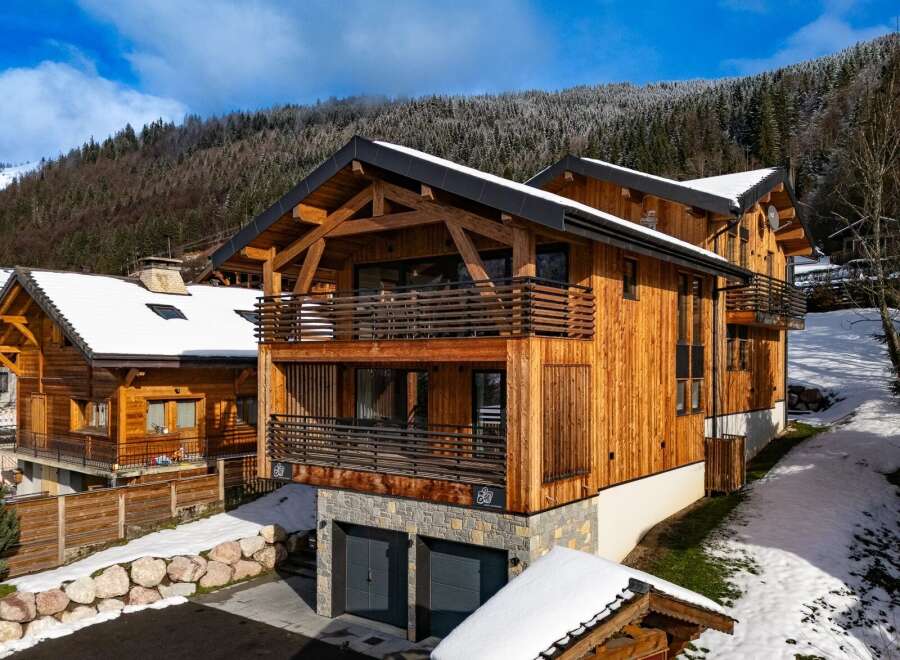 Discover the charm of this stunning wooden chalet nestled in a picturesque winter landscape.