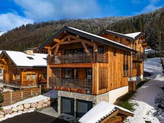 Discover the charm of this stunning wooden chalet nestled in a picturesque winter landscape.