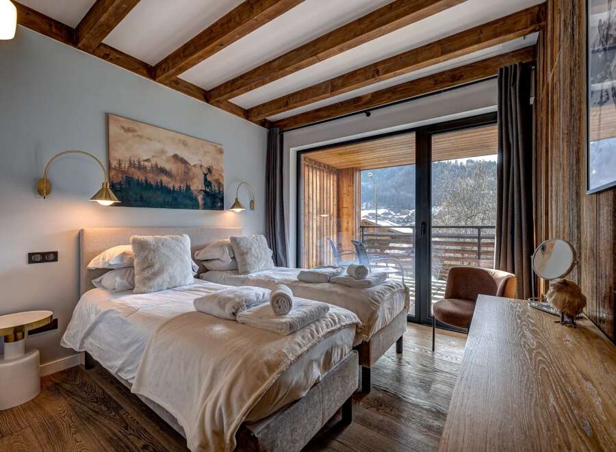 Experience luxury and comfort in this stunning bedroom featuring two twin beds, perfect for a relaxing getaway.
