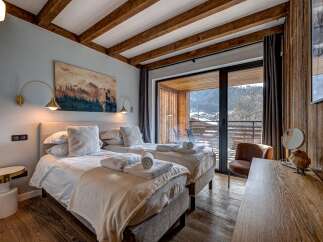 Experience luxury and comfort in this stunning bedroom featuring two twin beds, perfect for a relaxing getaway.