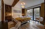 Experience the epitome of comfort in this stunning bedroom, featuring a cozy bed adorned with plush linens and a warm, inviting blanket.