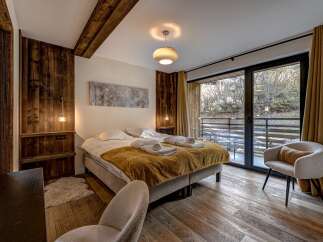 Experience the epitome of comfort in this stunning bedroom, featuring a cozy bed adorned with plush linens and a warm, inviting blanket.