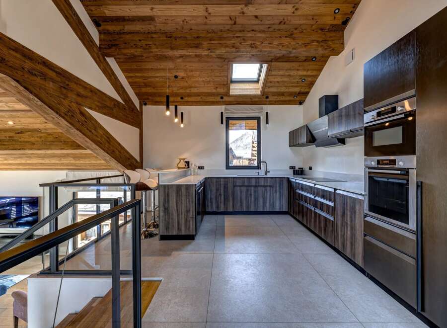 Experience luxury living in this stunning property, featuring a modern kitchen with sleek cabinetry and high-end appliances.