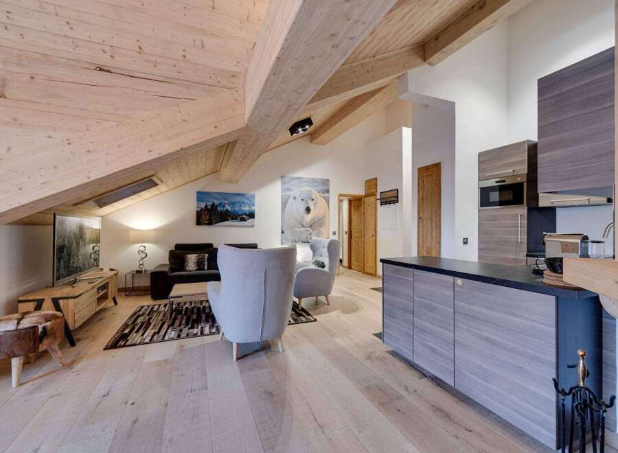 Experience luxury living in this stunning property, featuring a spacious open-plan layout with exposed wooden beams and a modern kitchen.