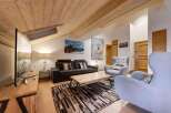 This stunning living room boasts a cozy atmosphere with its wooden ceiling and inviting decor.