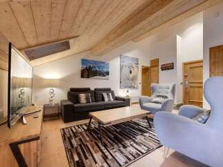 This stunning living room boasts a cozy atmosphere with its wooden ceiling and inviting decor.