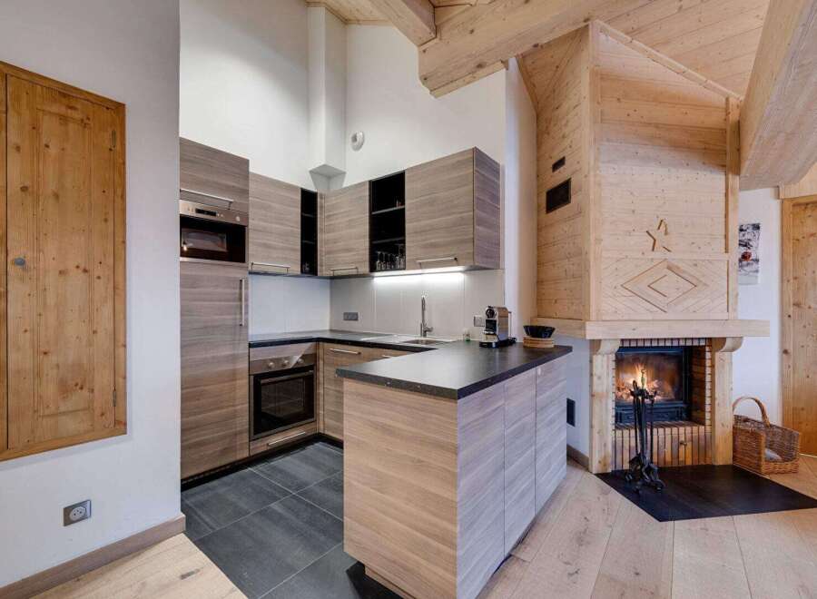 This stunning kitchen boasts a modern design with sleek cabinetry and a cozy fireplace.