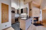 This stunning kitchen boasts a modern design with sleek cabinetry and a cozy fireplace.