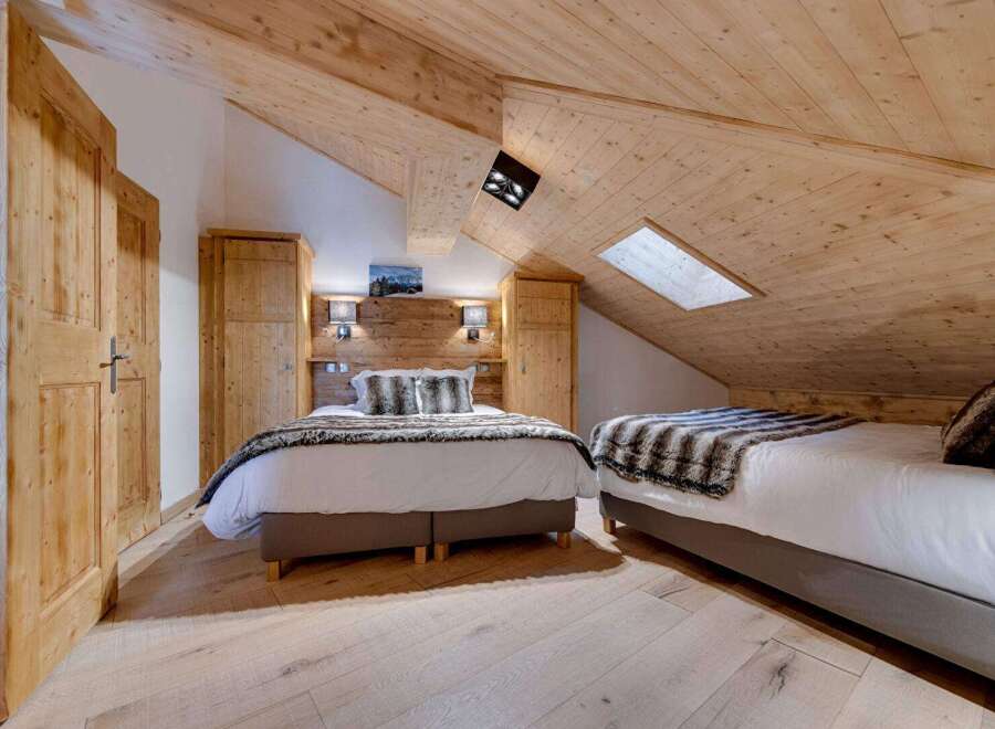 Experience the charm of this cozy bedroom featuring a unique wooden ceiling and flooring.