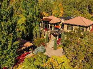 Nestled amidst lush greenery, this stunning property boasts a luxurious design with multiple levels and a charming balcony.