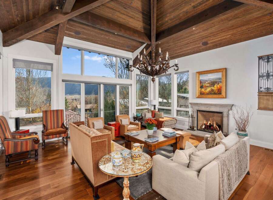 Experience luxury living in this stunning home featuring a grand living room with a cozy fireplace and a beautiful chandelier.