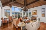 Experience luxury living in this stunning home featuring a grand living room with a cozy fireplace and a beautiful chandelier.