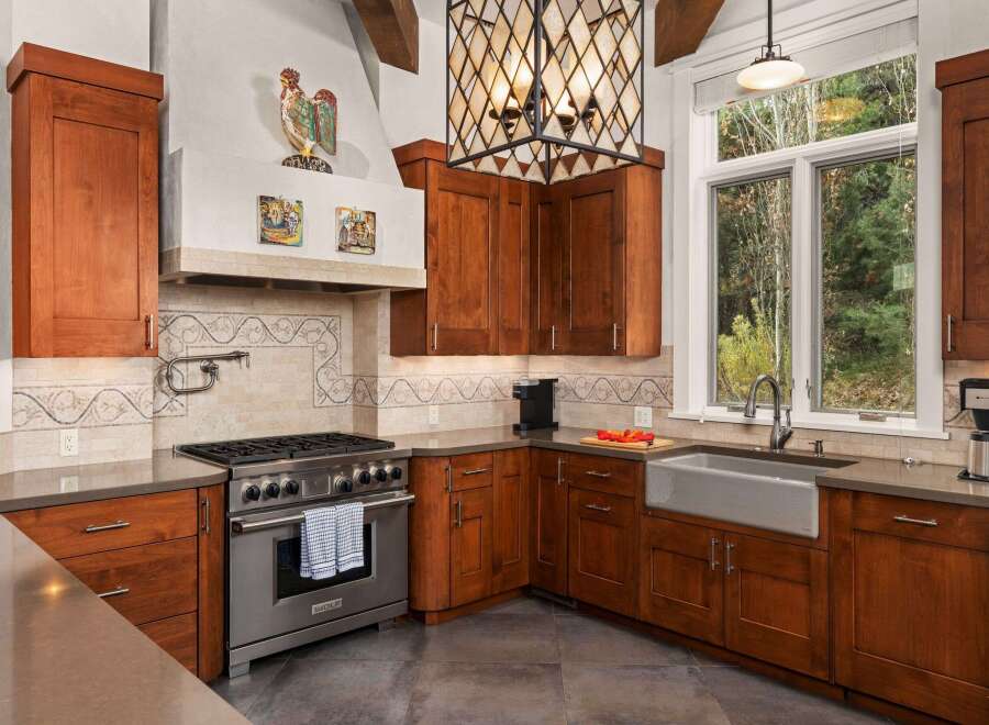 This stunning kitchen boasts custom cabinetry, a high-end Wolf range, and a farmhouse sink, perfect for culinary enthusiasts.